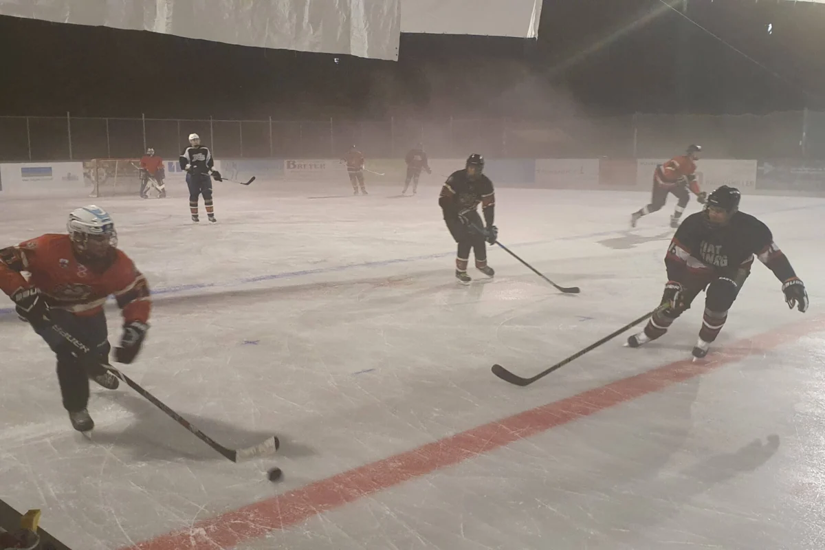 Chiefs Training Eishockey Eishockeyspieler trainieren nachts auf dem beleuchteten Eisplatz in Lindenberg, im Hintergrund ist Nebel zu sehen.