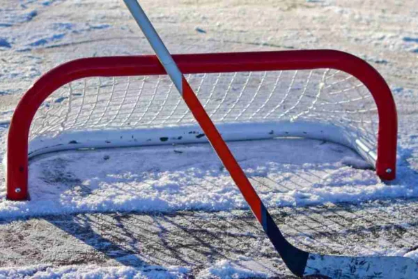 schlaegerlauf Hockeytor auf einer Eisfläche mit einem davor stehenden Hockeyschläger im Eisplatz Lindenberg.