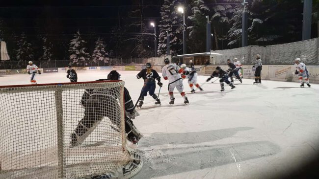 WAEL-Playoffs 2022 Eishockeyspiel bei Nacht auf dem Eisplatz Lindenberg, Spieler in Aktion vor dem Tor, winterliche Kulisse.