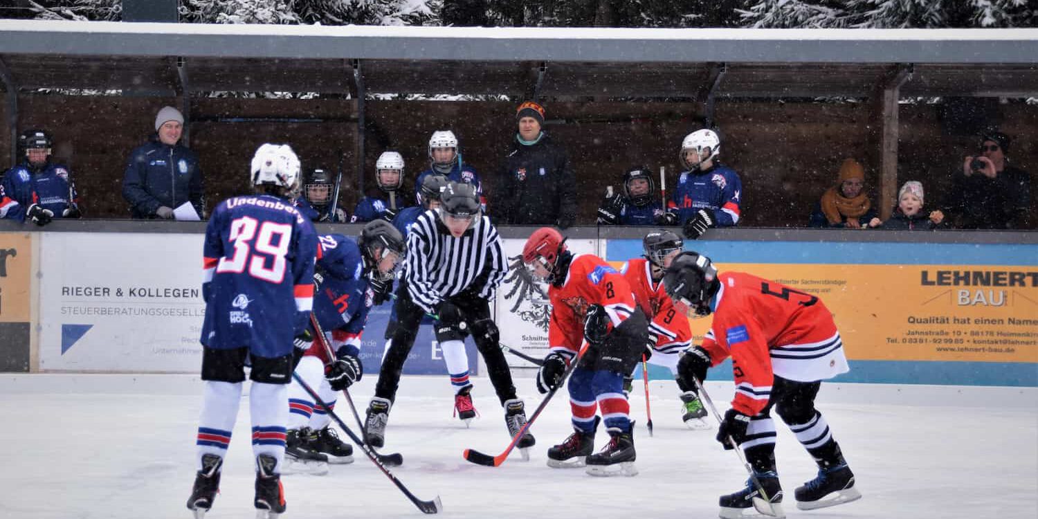 Jugend-eishockey-tvl-2023 Jugendliche beim Eishockeyspiel auf Eisplatz Lindenberg, Schiedsrichter bereitet das Bully zwischen zwei Teams vor.