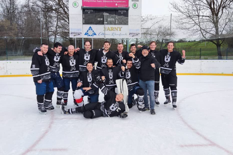 black flyers-eiskratzer Eishockeyteam Black Flyers auf dem Eisplatz Lindenberg, fröhlich posierend vor der Anzeigetafel im Freien.