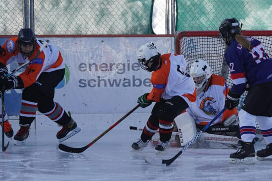 Eishockeyspieler kämpfen um den Puck vor dem Tor auf dem Eisplatz Lindenberg, TVL Bulls in orange und schwarz.