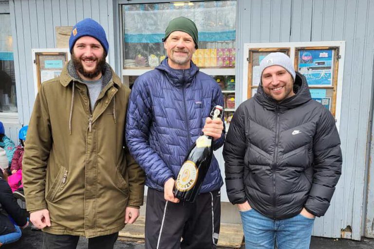 charity-cup-siegerfoto-2 Drei Männer posieren vor einem Gebäude, der mittlere hält eine große Flasche mit Aufschrift "Walter".