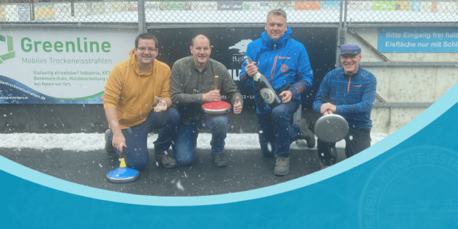 Vier Männer mit Eisstöcken posieren lachend vor Werbebannern auf einem verschneiten Eisplatz.