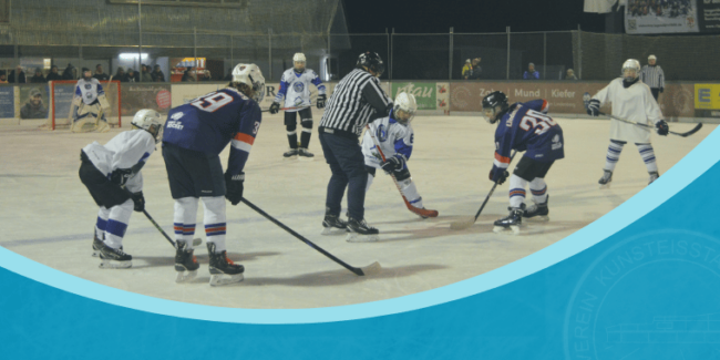 Eishockey-Spieler treten beim Bully-Duell auf dem Eisplatz Lindenberg gegeneinander an, unter Flutlicht.