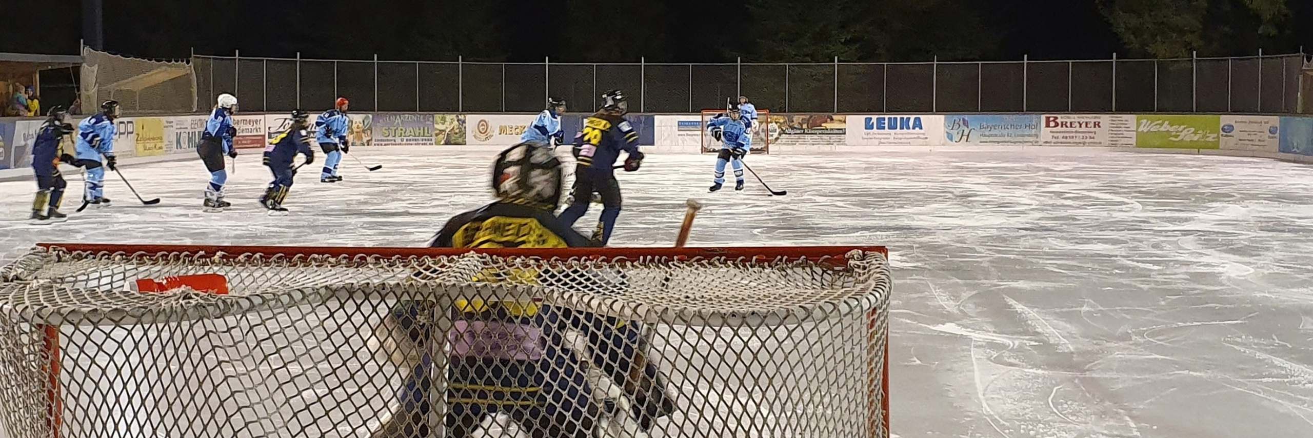 Damen-Eishockey am Eisplatz Lindenberg: Spielszene vor dem Tor mit Torhüterin im Vordergrund